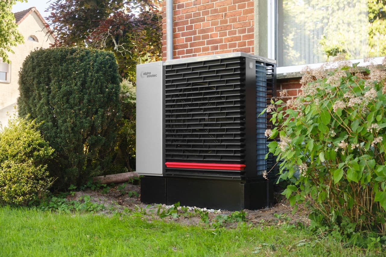 Thermopompe installée à côté d’une maison de brique
